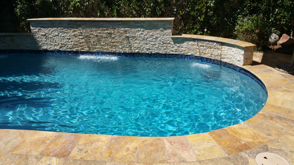 Foto de piscina con fuente tradicional renovada de tamaño medio a medida en patio trasero con suelo de baldosas