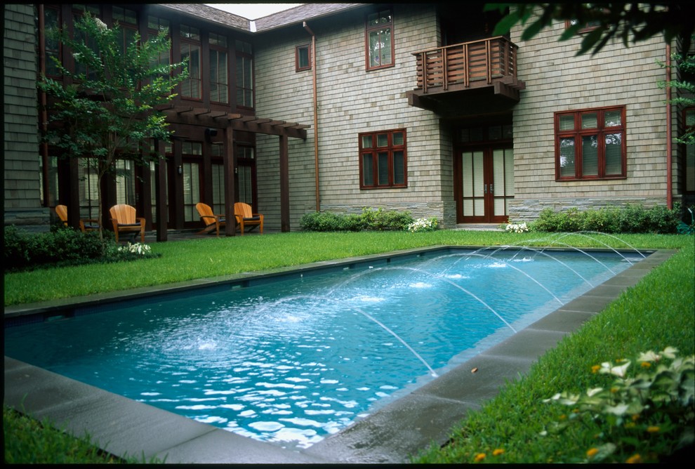 Immagine di una piscina monocorsia classica rettangolare di medie dimensioni e dietro casa con fontane