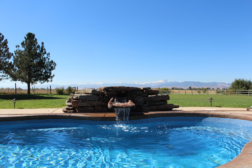 На фото: бассейн среднего размера, произвольной формы на заднем дворе в стиле фьюжн с фонтаном и покрытием из бетонных плит с