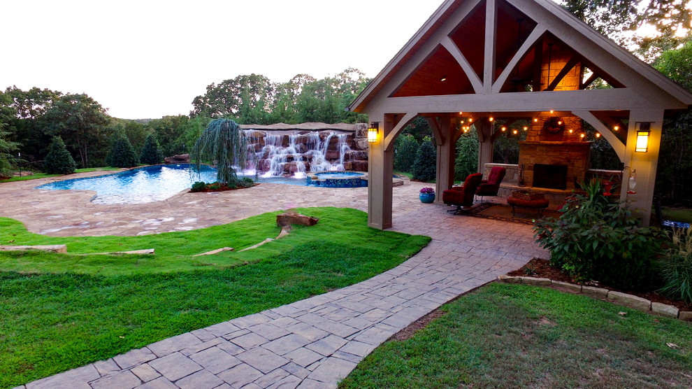 Immagine di una piscina naturale chic personalizzata di medie dimensioni e dietro casa con fontane e pavimentazioni in pietra naturale