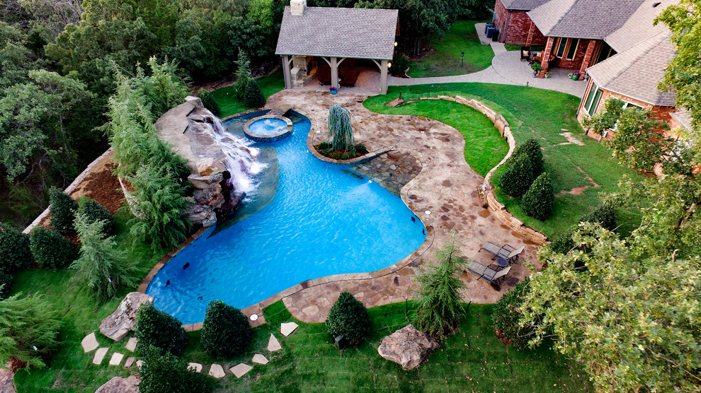 Пример оригинального дизайна: естественный бассейн среднего размера, произвольной формы на заднем дворе в стиле неоклассика (современная классика) с фонтаном и покрытием из каменной брусчатки