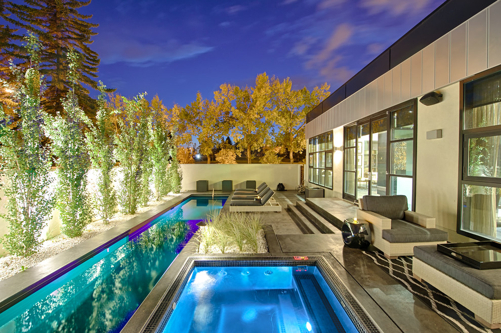 Kleiner Moderner Pool hinter dem Haus in rechteckiger Form mit Betonplatten in Calgary