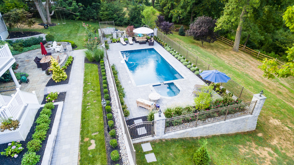 Imagen de piscinas y jacuzzis naturales modernos grandes rectangulares en patio trasero con adoquines de ladrillo