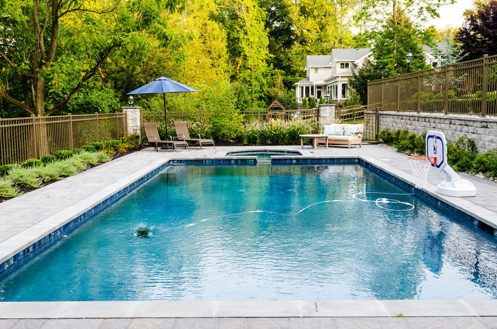 Cette image montre une grande piscine naturelle et arrière minimaliste rectangle avec un bain bouillonnant et des pavés en brique.