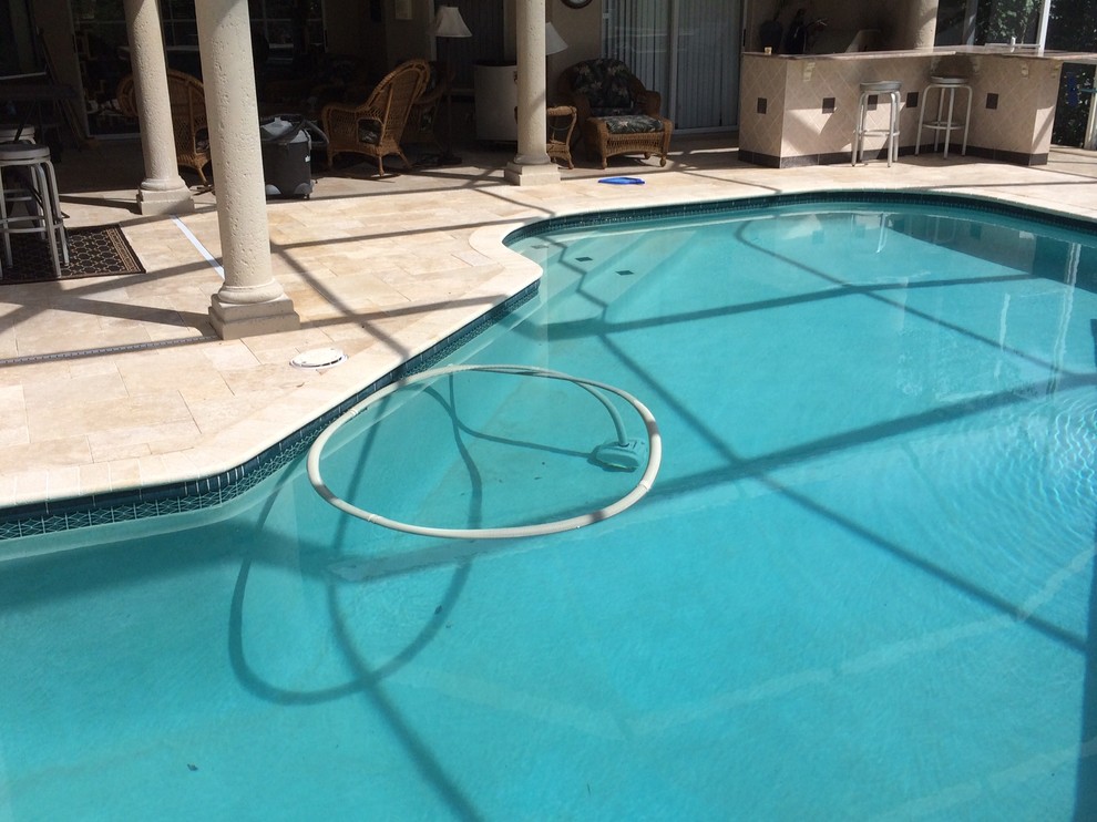 Foto de piscina clásica en patio trasero con adoquines de piedra natural