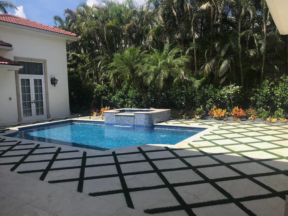 This is an example of a medium sized mediterranean back rectangular swimming pool in Miami with natural stone paving.