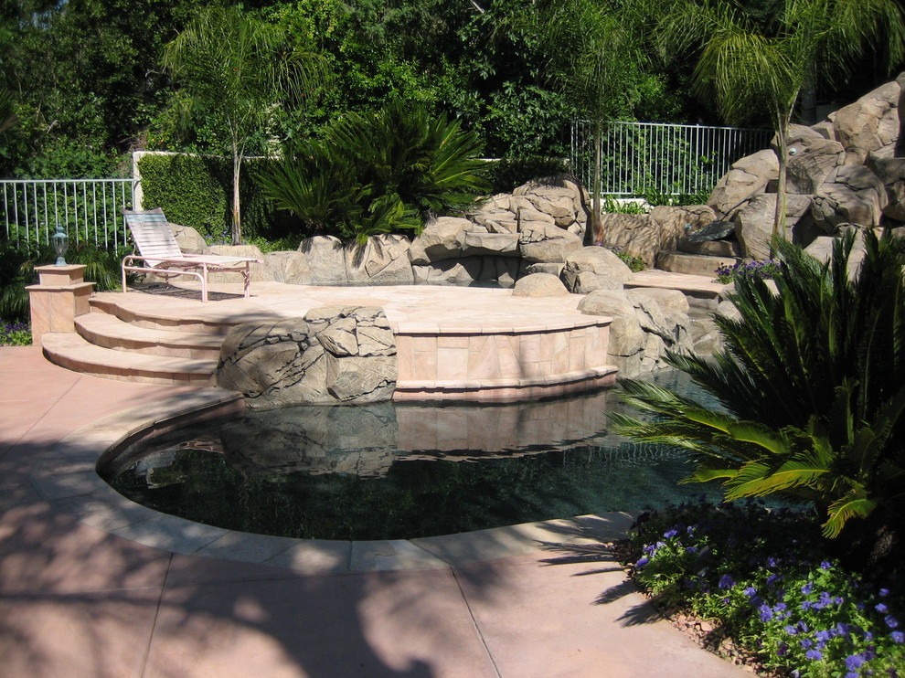 Exemple d'une piscine arrière montagne de taille moyenne et sur mesure avec un toboggan et des pavés en pierre naturelle.
