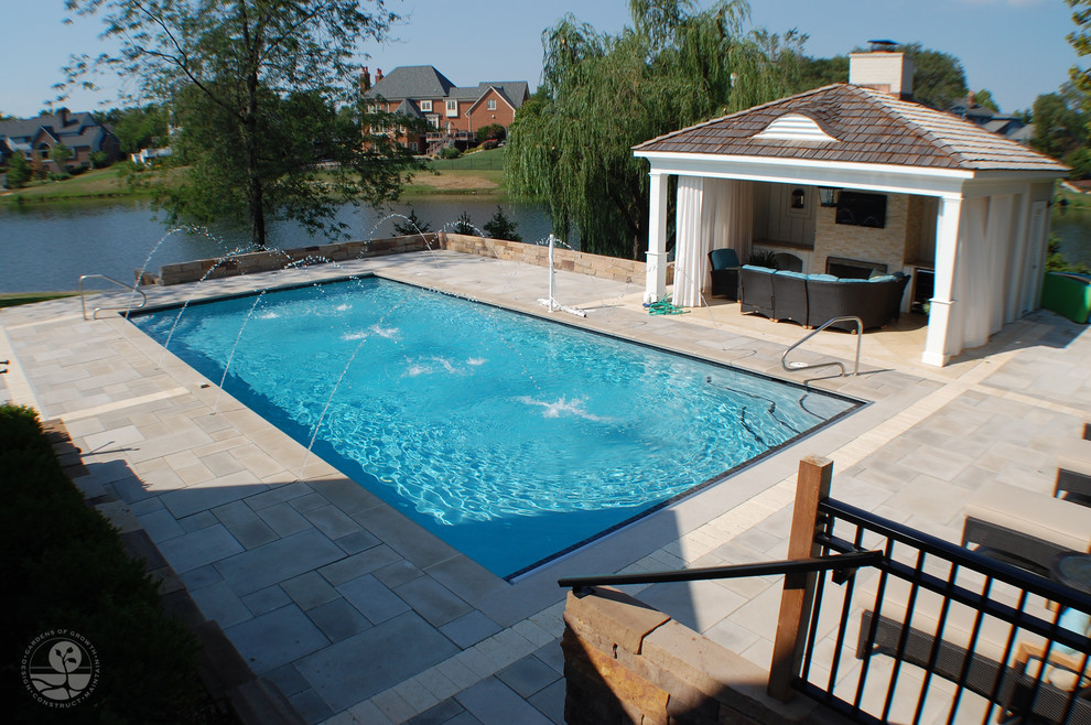 Esempio di una grande piscina monocorsia design rettangolare dietro casa con una dépendance a bordo piscina e piastrelle
