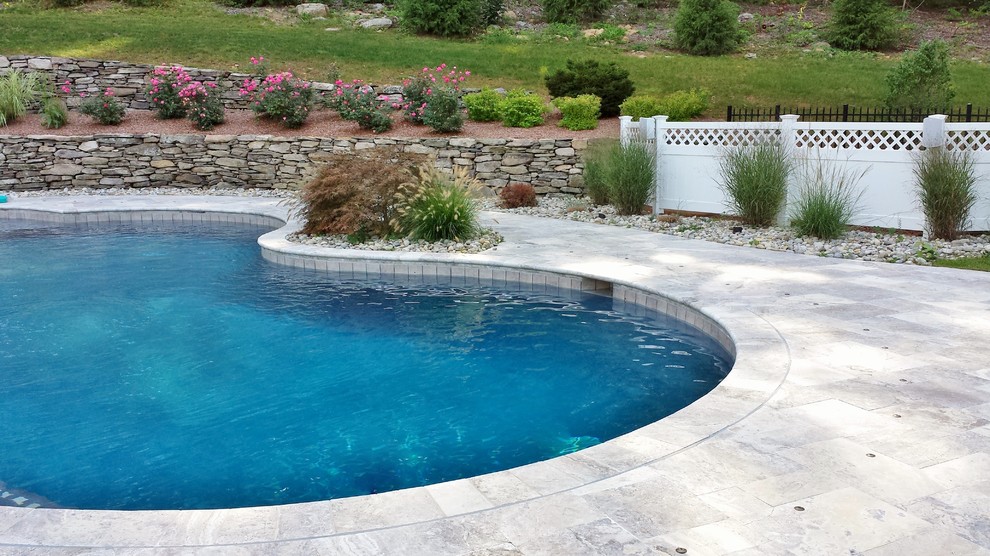 Idee per un'ampia piscina naturale chic personalizzata dietro casa con pavimentazioni in pietra naturale e una dépendance a bordo piscina