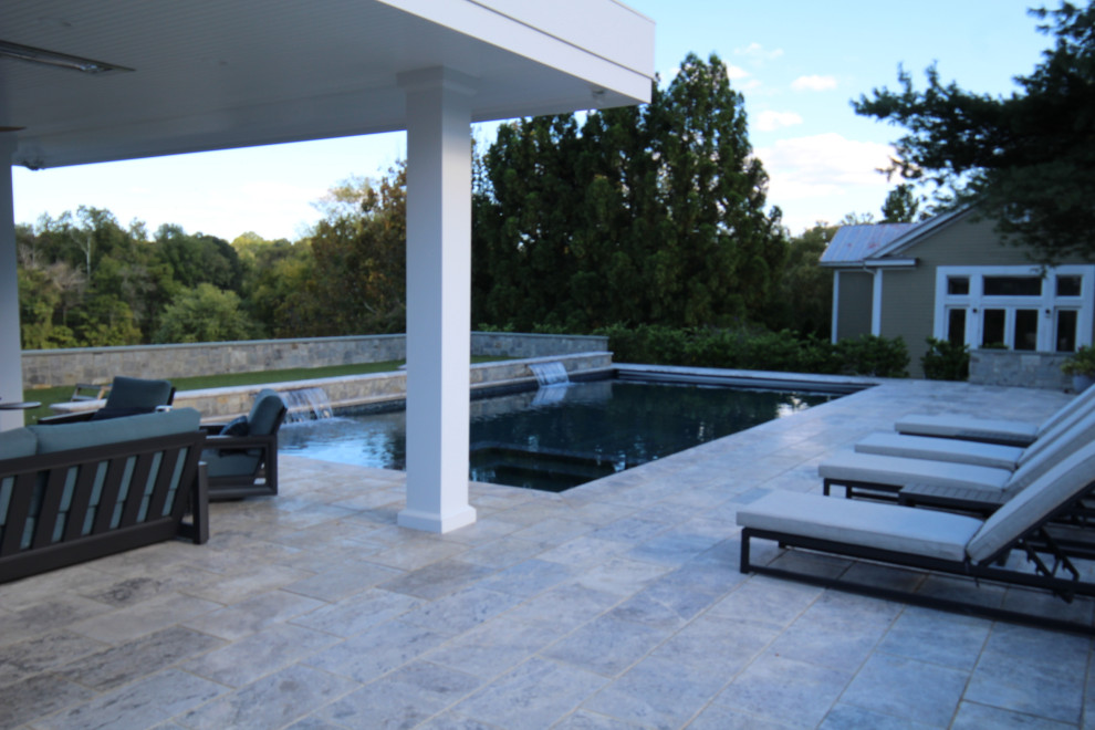 Modelo de casa de la piscina y piscina natural actual grande rectangular en patio trasero con adoquines de piedra natural