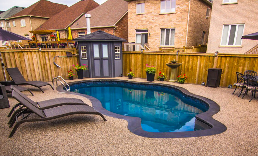 На фото: маленький бассейн в форме фасоли на заднем дворе в стиле неоклассика (современная классика) с покрытием из декоративного бетона для на участке и в саду