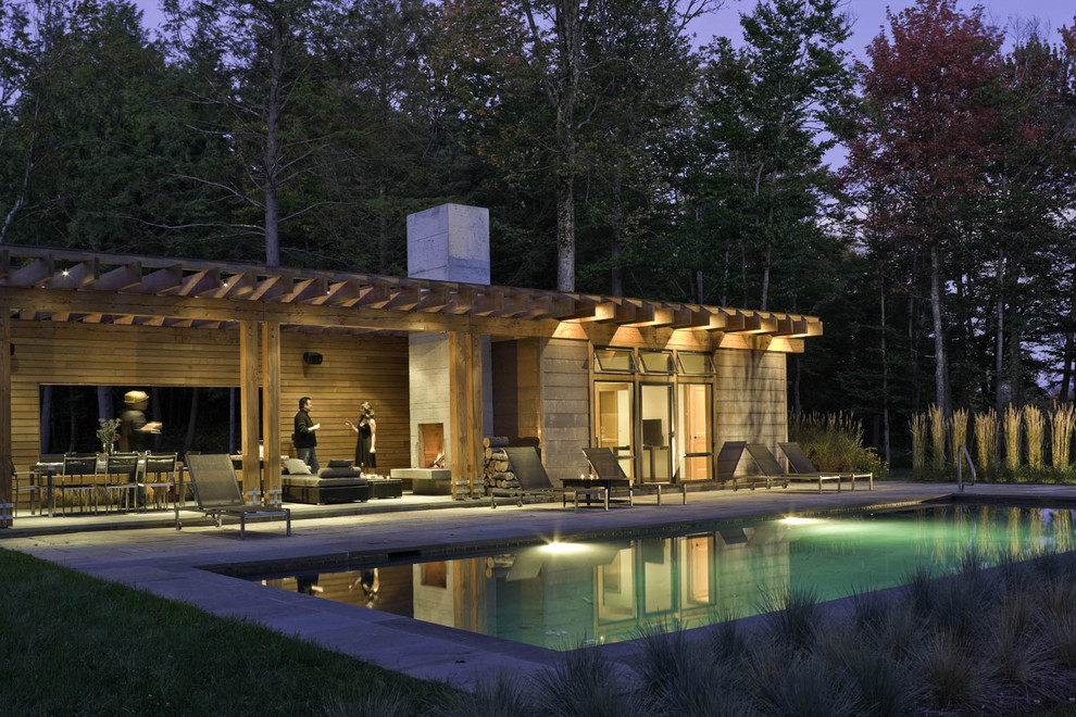 На фото: прямоугольный бассейн на заднем дворе в современном стиле с домиком у бассейна с