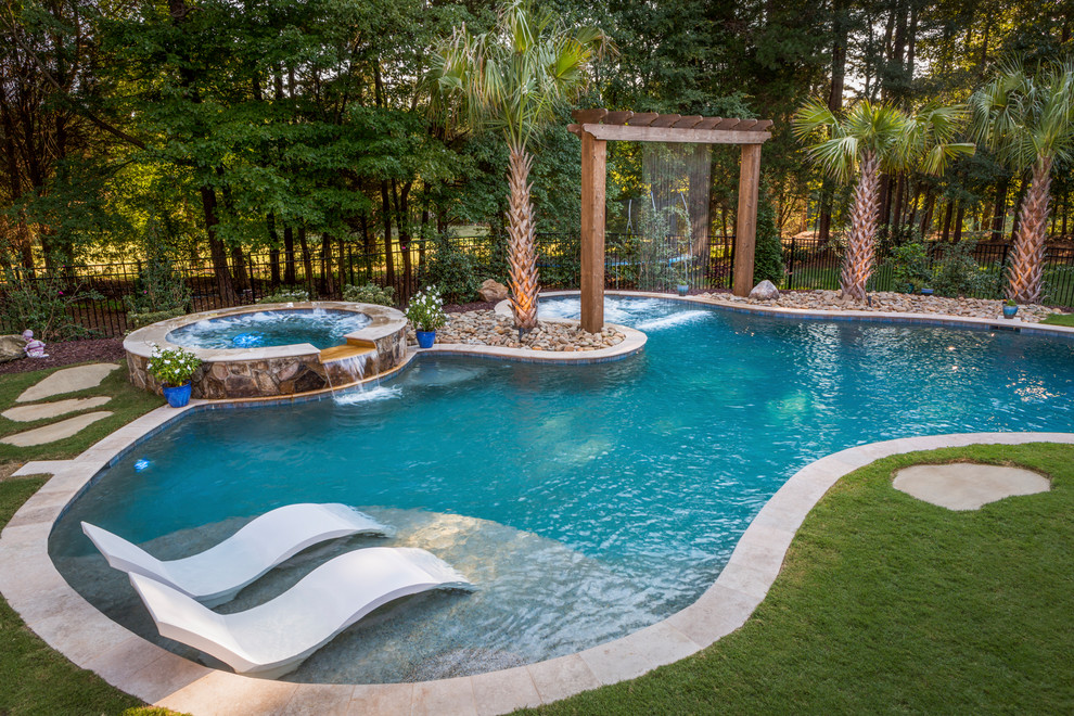 Example of a classic backyard custom-shaped hot tub design in Charlotte