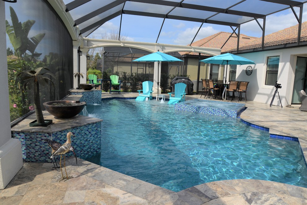 На фото: большой бассейн произвольной формы на заднем дворе в морском стиле с джакузи и покрытием из плитки