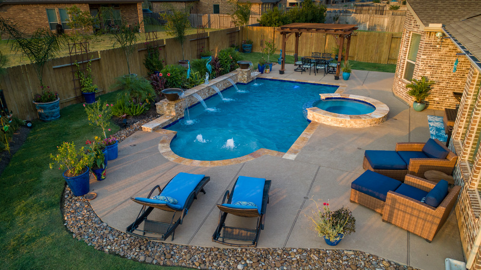 Imagen de piscina con fuente contemporánea de tamaño medio rectangular en patio trasero con adoquines de piedra natural