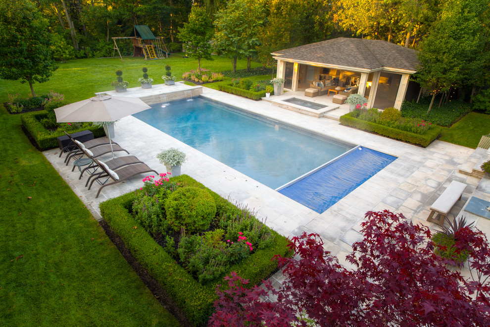 Foto di una grande piscina chic rettangolare dietro casa con una dépendance a bordo piscina e pavimentazioni in pietra naturale