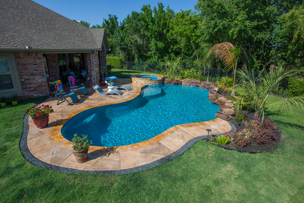 Foto de piscina exótica de tamaño medio a medida en patio trasero con suelo de hormigón estampado