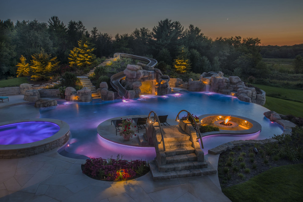 Ispirazione per un'ampia piscina a sfioro infinito personalizzata dietro casa con una vasca idromassaggio e pavimentazioni in pietra naturale
