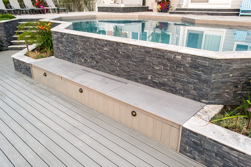Réalisation d'une piscine arrière tradition de taille moyenne et sur mesure avec un bain bouillonnant et une terrasse en bois.