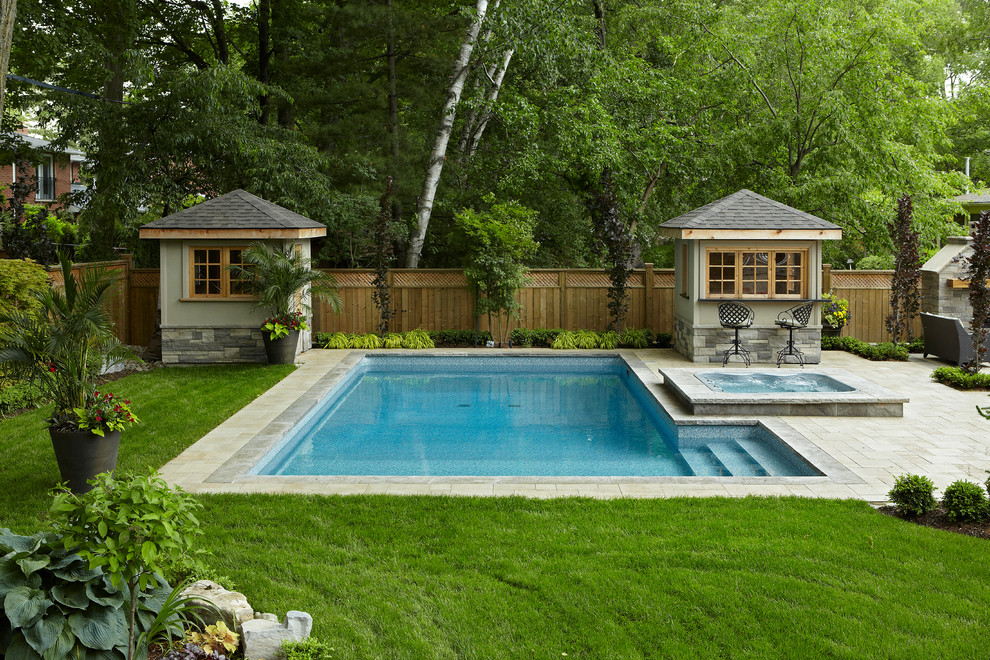 Foto de piscinas y jacuzzis alargados actuales de tamaño medio rectangulares en patio trasero con adoquines de hormigón