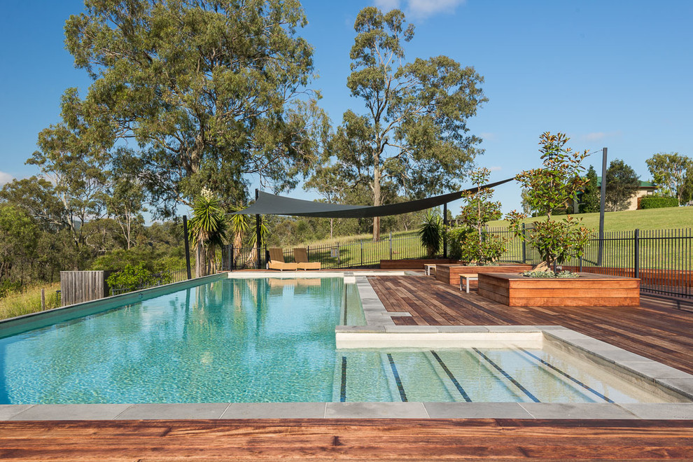 Inspiration pour un grand couloir de nage arrière rustique sur mesure avec une terrasse en bois.