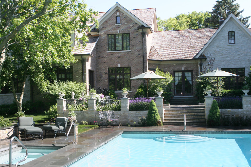Photo of a classic back rectangular swimming pool in Milwaukee with natural stone paving.