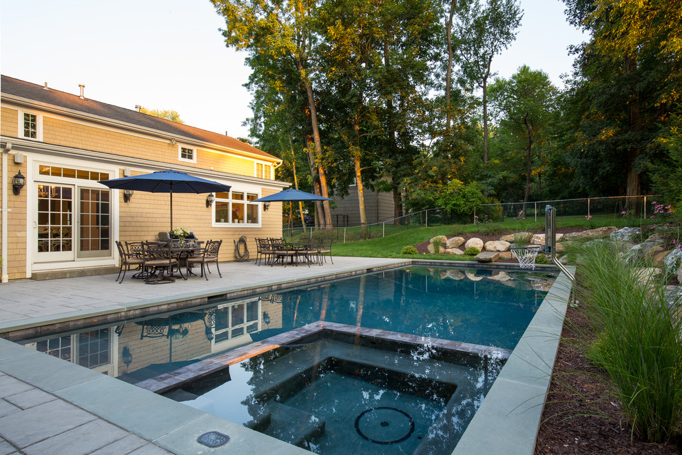 Imagen de piscinas y jacuzzis alargados tradicionales grandes rectangulares en patio trasero con adoquines de piedra natural