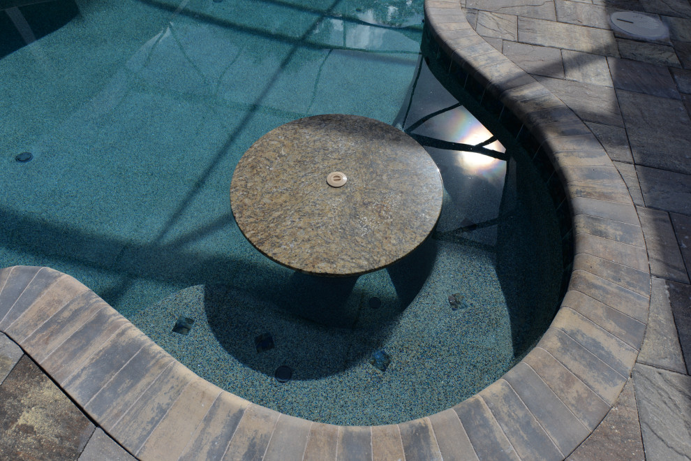 Large classic back custom shaped hot tub in Orlando with brick paving.