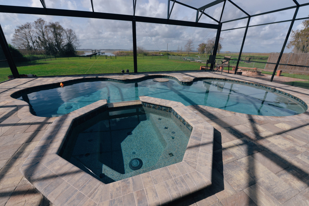 Idées déco pour une grande piscine arrière classique sur mesure avec un bain bouillonnant et des pavés en brique.