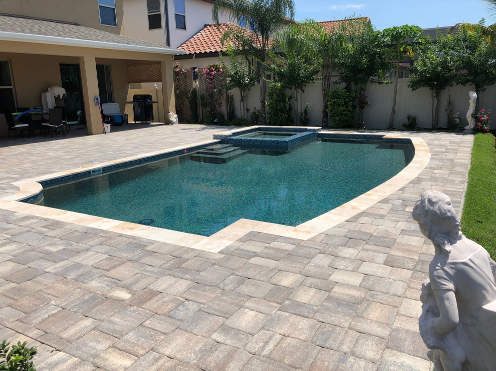 Immagine di una piscina moderna rettangolare di medie dimensioni e dietro casa con una vasca idromassaggio e pavimentazioni in mattoni