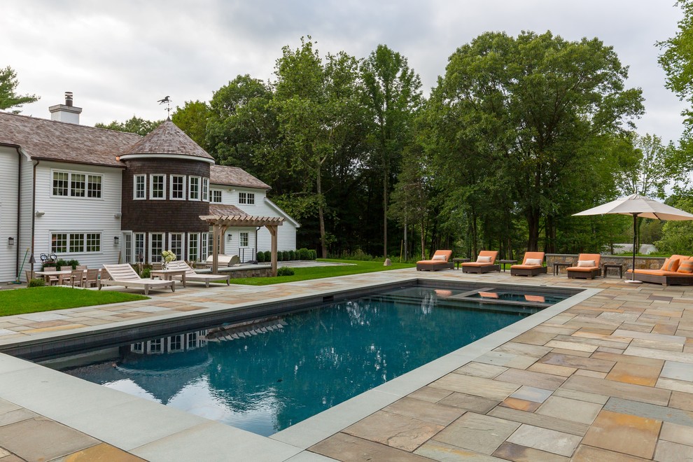 Modelo de piscinas y jacuzzis alargados tradicionales renovados de tamaño medio rectangulares en patio trasero con adoquines de piedra natural