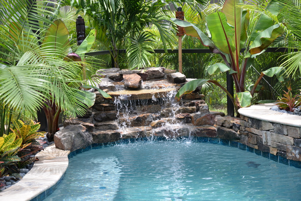 Exemple d'une très grande piscine naturelle et arrière bord de mer sur mesure avec un bain bouillonnant et des pavés en pierre naturelle.