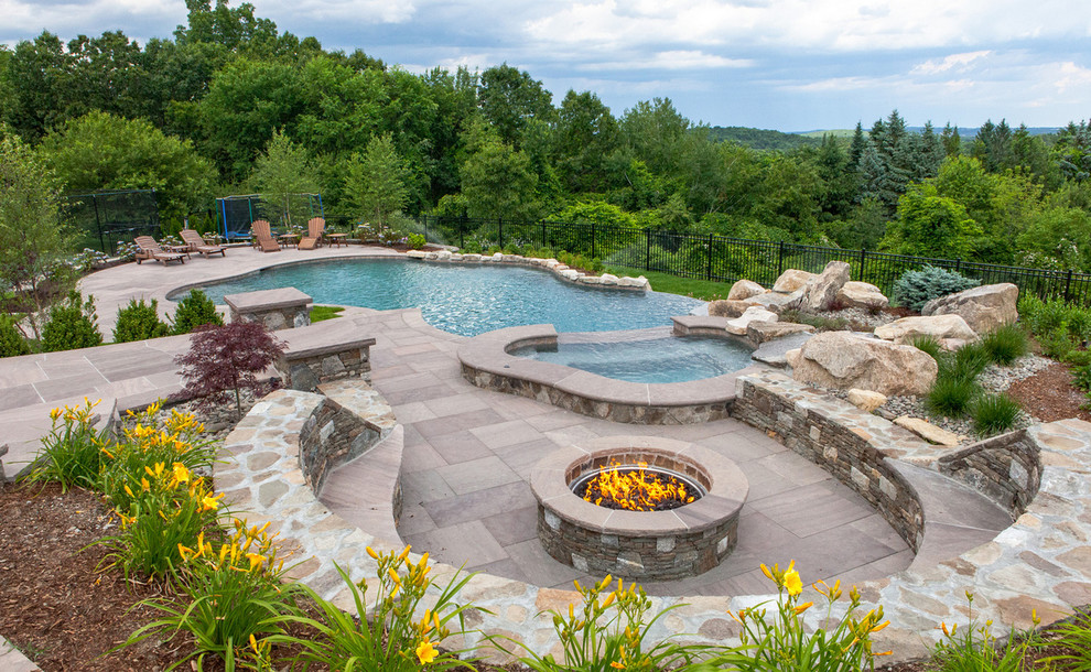 Foto di una piscina naturale classica personalizzata di medie dimensioni e dietro casa con fontane e pavimentazioni in pietra naturale