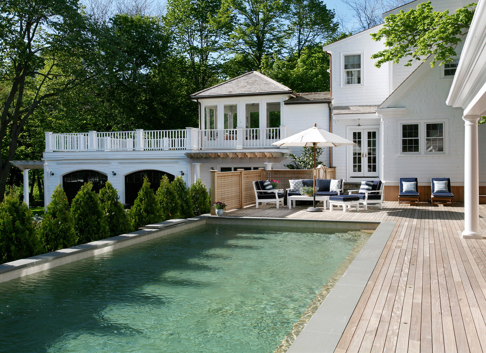 Pool house - large traditional backyard rectangular lap pool house idea in Boston with decking