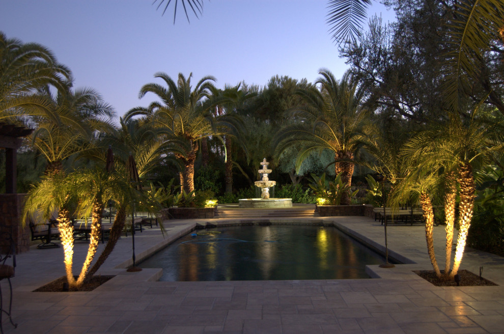 Ejemplo de piscina marinera extra grande rectangular en patio trasero con paisajismo de piscina y adoquines de hormigón