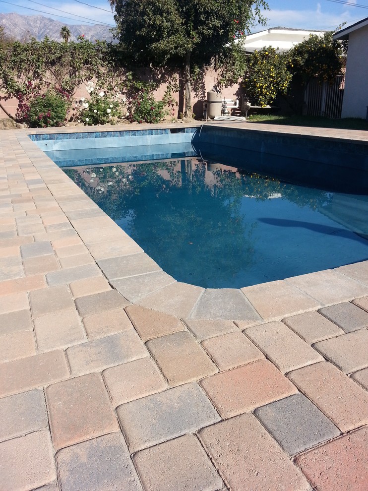 Imagen de piscina clásica renovada de tamaño medio rectangular en patio trasero con adoquines de ladrillo