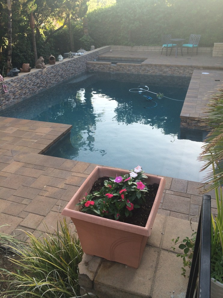 Foto di una piscina chic personalizzata di medie dimensioni e dietro casa con pavimentazioni in pietra naturale