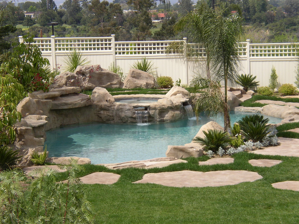 Example of a mid-sized island style backyard stone and custom-shaped natural hot tub design in Los Angeles