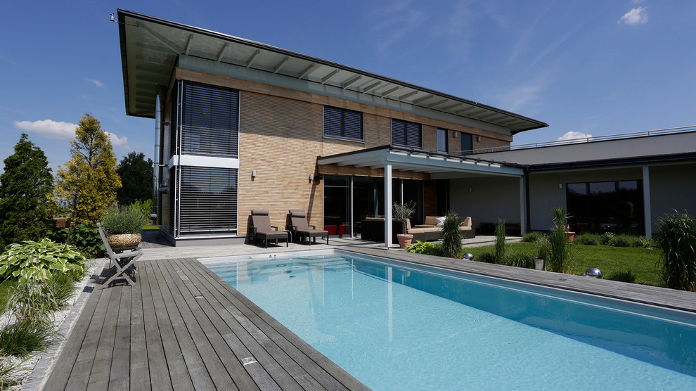 Imagen de piscina mediterránea grande rectangular en patio trasero con entablado