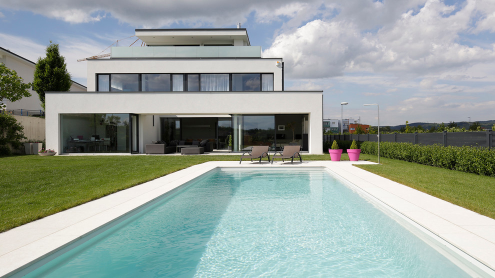 Großer Moderner Pool hinter dem Haus in rechteckiger Form in Sonstige