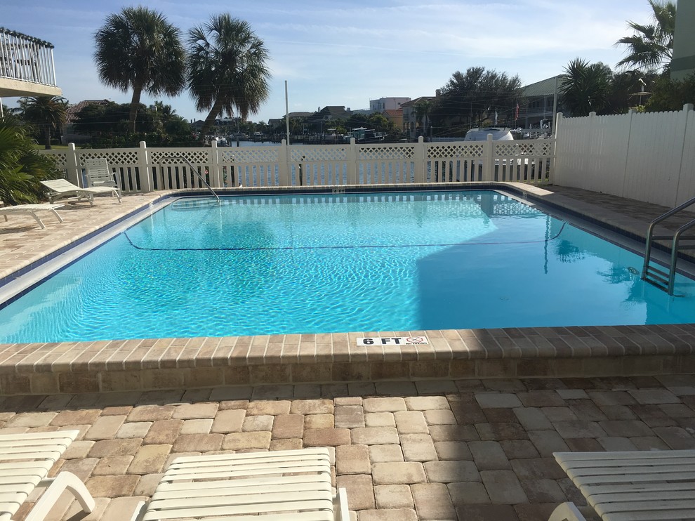 Photo of a medium sized nautical courtyard rectangular lengths swimming pool in Tampa with brick paving.