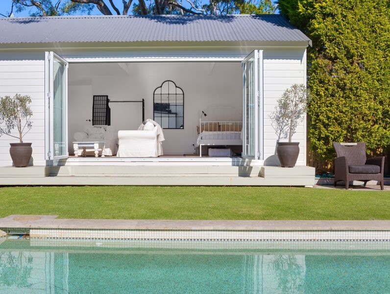 Modelo de casa de la piscina y piscina natural marinera pequeña rectangular en patio trasero con adoquines de piedra natural