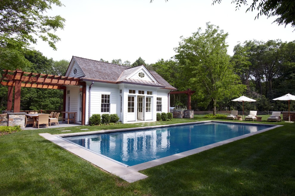 Diseño de piscina alargada marinera rectangular en patio trasero con losas de hormigón