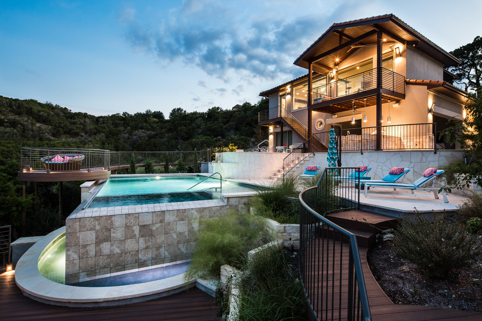 Immagine di una grande piscina fuori terra mediterranea rettangolare dietro casa con piastrelle e una vasca idromassaggio