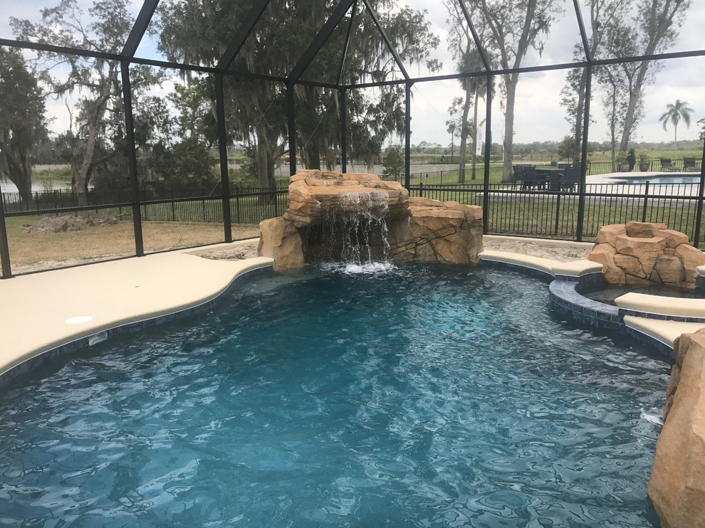 Ejemplo de piscina con fuente natural exótica de tamaño medio en patio trasero