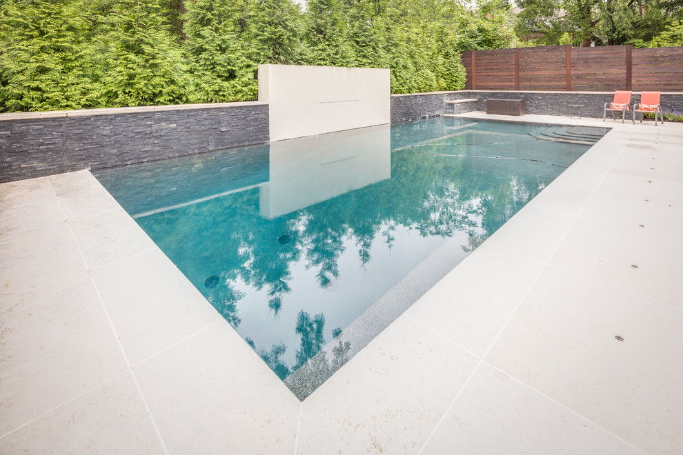 Пример оригинального дизайна: спортивный, прямоугольный бассейн среднего размера на заднем дворе в современном стиле с фонтаном и покрытием из декоративного бетона