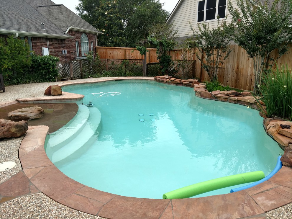 Idées déco pour une piscine naturelle et arrière exotique de taille moyenne et sur mesure avec un point d'eau et du gravier.