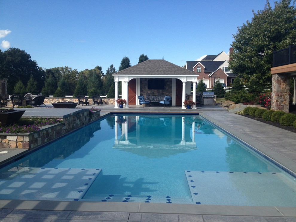На фото: большой спортивный, прямоугольный бассейн на заднем дворе в классическом стиле с домиком у бассейна и покрытием из каменной брусчатки с