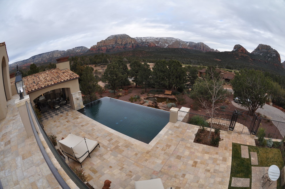 Cette photo montre une piscine arrière méditerranéenne de taille moyenne et rectangle avec des pavés en pierre naturelle.