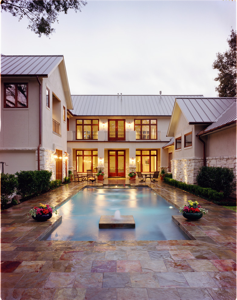 Inspiration for a medium sized classic courtyard custom shaped lengths swimming pool in Houston with a water feature and stamped concrete.